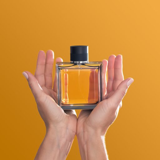 perfume bottle in hands on an orange background 2023 06 27 01 26 13 utc